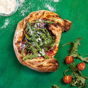 Calzone Ripieno folded pizza on green background